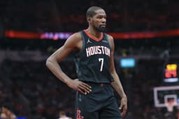Kevin Durant en tenue des Houston Rockets, debout sur le parquet avec les mains sur les hanches lors d’un match NBA.